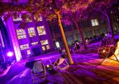 Strandstühle vor der Städtischen Galerie bei Nacht, auf Einigen liegen Besucher