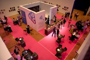 Blick in den Lichthof der Städtischen Galerie, viele Besucherinnen und Besucher in der Ausstellung, auch eine Bar und ein DJ-Pult